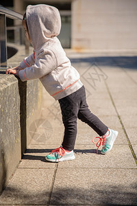 在城市广场训练前穿着运动鞋和连帽衫的小女孩图片