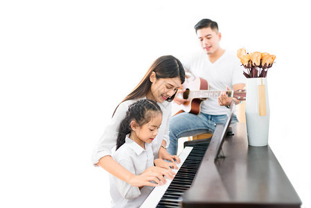 亚洲家庭母女弹钢琴父亲在家乐队弹吉他图片