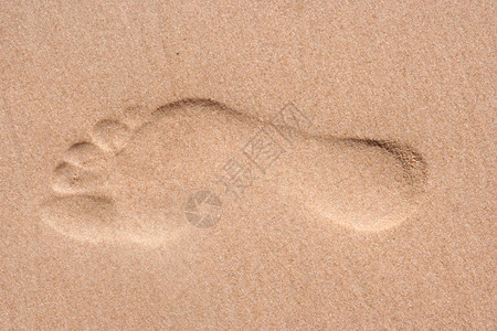 正确的男脚印在细沙滩上假日背景图片