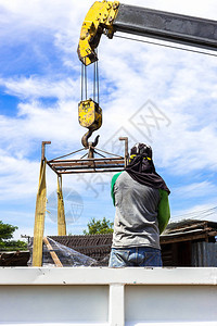 建造筑工地的男子为大楼工作使用起重机图片