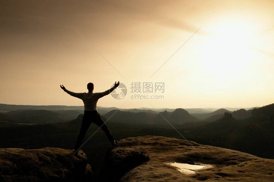 快乐的男人在露天悬崖上举起的手势胜利图片