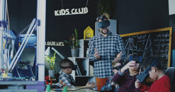 有一组儿童在学校上课和在护目镜中学习VR技术的图片