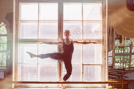 男芭蕾舞者在大窗户前跳舞站在窗台上图片