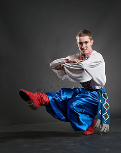 在黑暗背景下跳舞的年轻哥萨克人图片
