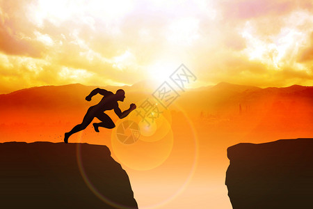 男人物跳过峡谷的悬崖冲刺图片