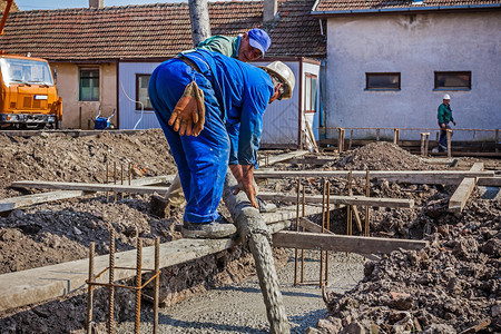 建筑工人在建筑基础上浇注混凝土图片