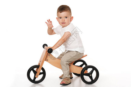 小司机第一次尝试新的自行车骑着自行车的婴儿在白色背景上被孤立了图片