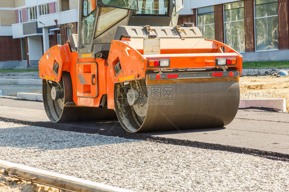 工作在道路建造场所的压路机图片