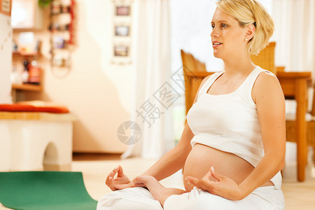 坐在她家地板上的孕期瑜伽图片