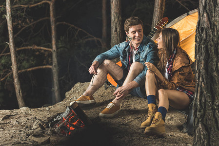在野营旅行中用棍子烤棉花糖的幸福夫妻图片