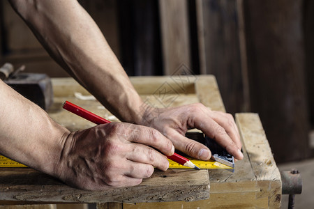 木匠的手用铅笔和尺子测量木板图片