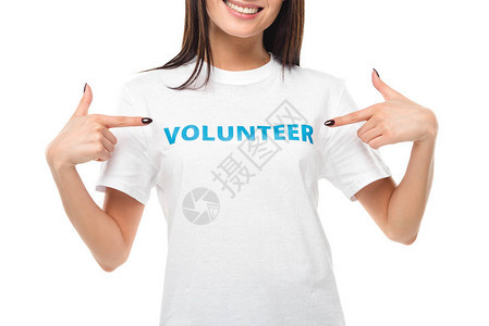 女志愿人员指着白色被孤立的T恤衫上的标志图片