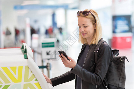 在机场使用智能手机应用程序和值机获取登机牌的休闲白人女在机背景图片