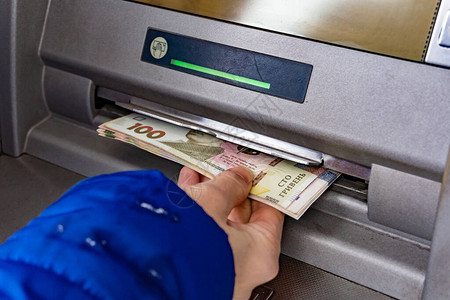 一名妇女在ATM取款乌克兰的现金格里夫纳图片