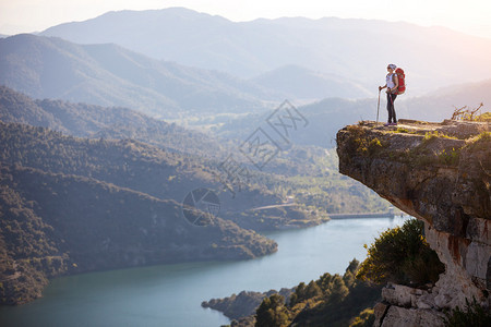 女登山者站在悬崖上图片