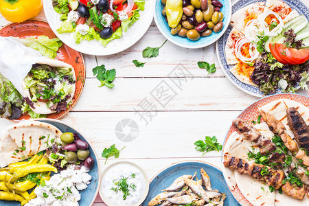 希腊食物背景Meze陀螺仪烤肉串炸鱼皮塔饼希腊沙拉tzatziki各种羊乳酪橄榄和蔬菜传统的希腊菜肴套装文本的空间顶视背景图片