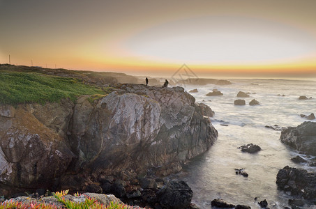 日落时地平线上有3个年轻人的海景图片
