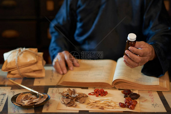 亚洲传统医学的开业医师提供他准备的药物图片