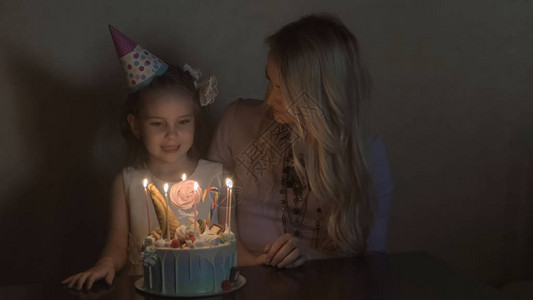 妈和女儿在生日蛋糕上吹蜡烛图片