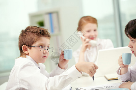 小儿童在办公室喝咖啡和交流小儿童在打商业游图片