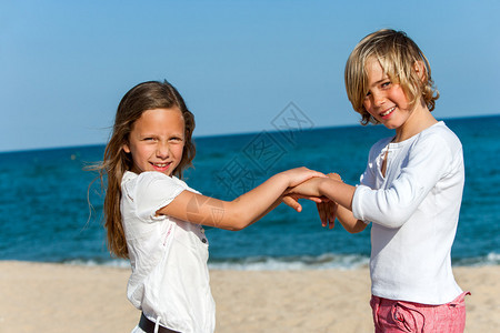 两名儿童在海滩玩手图片