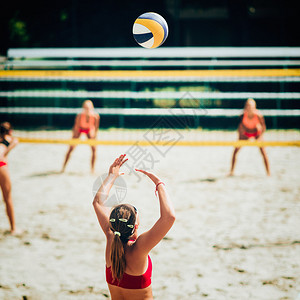 女团队在海滩排球比赛中打沙滩排球关图片