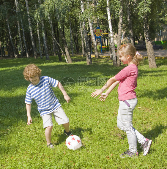 男女儿童在院子里打橄榄球躺在草地上图片