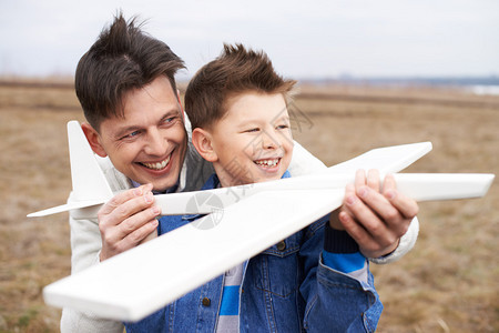 喜悦的男孩与玩具飞机和他父亲一图片