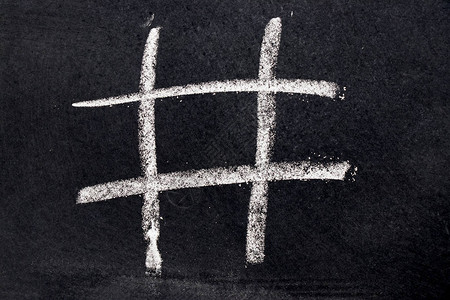 黑色板背景上的白色粉笔画成tictacto图片素材