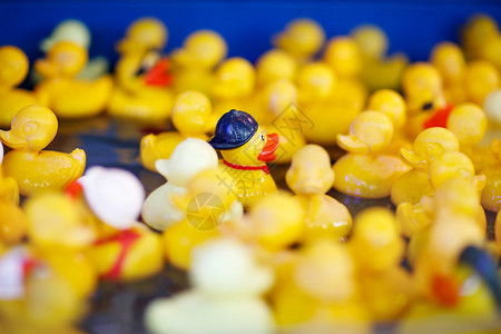 在公平市场上与孩子玩游戏的一群黄色橡皮鸭背景图片