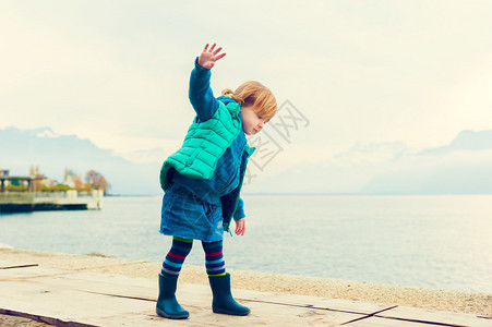 身穿绿色腰衣牛仔裙和蓝雨靴的2岁可爱幼儿女图片