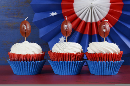 红白和蓝主题纸杯蛋糕配有超级碗周日派对的足球选手或者拼贴橄榄球图片