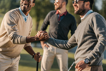 快乐的多文化朋友在高尔夫球场打图片