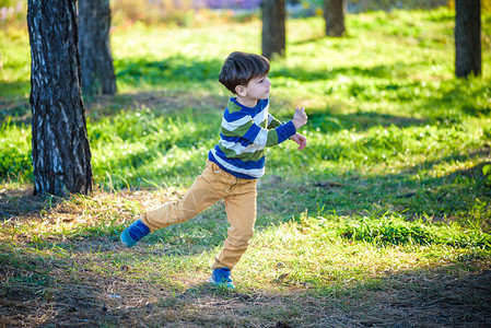 男孩在森林或公园里扔泡沫飞机图片