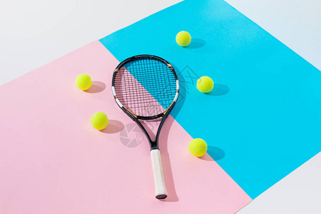 蓝色和粉色纸上的网球拍和黄色球背景图片