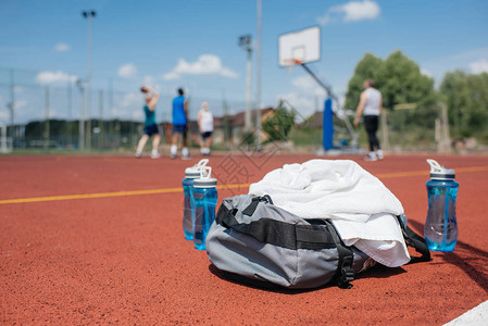 运动水瓶球袋和篮球运动员在操场上的选图片