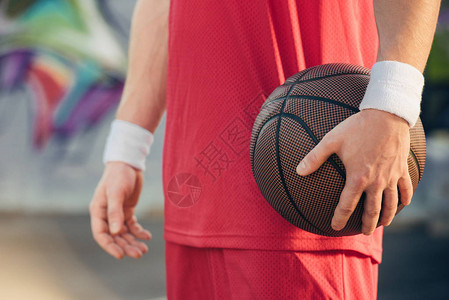 红运动装篮球运动员在街上举行篮球比图片