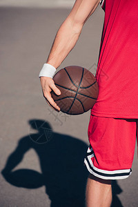 体育运动员在街上举行篮球图片