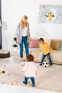 快乐的妈和可爱的小孩在家里玩足球图片