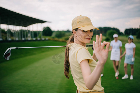高尔夫俱乐部在高尔夫球场显示OK标志的女图片