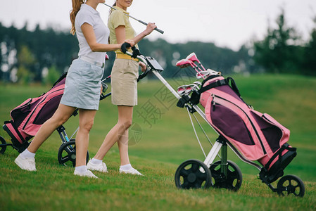 女高尔夫球手在高尔夫球场上行图片