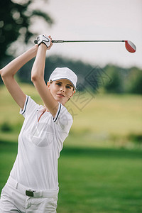 高尔夫球场上手拿高尔夫球杆的女高尔图片