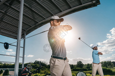 高尔夫球员的低角视野相信戴太阳镜和帽子打图片