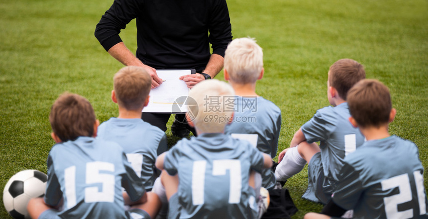 鼓励男孩足球队的教练足球队与教练在体育场与青年足球队的教练男孩听教练的指示教图片