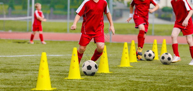 孩子们的足球训练营男孩们在田野里练习运球员发展良好的足球运技巧孩子们用球和锥体训练足球激流回旋训练以提高图片