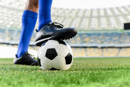 在体育场球穿蓝袜子和足球鞋的足球图片