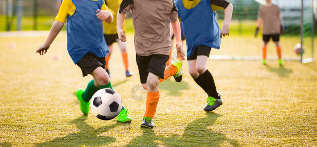 孩子们玩足球比赛儿童足球比赛男孩跑和踢足球背景中的图片