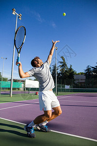 职业网球运动员在阳光明媚的夏日早晨在网球场上打网球图片