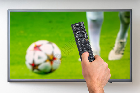 男人在电视上观看足球比赛手握图片