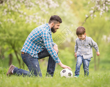 年幼的父亲和他的小儿子在足球图片